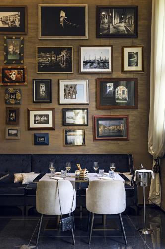a dining room with a table and some pictures on the wall at The Venice Times in Venice