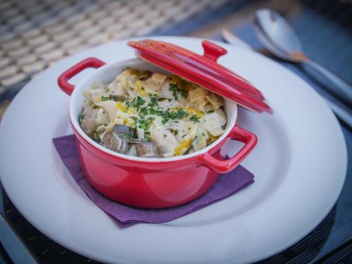 a red cup of soup with red utensils on a plate at Hôtel Inn Design Resto Novo Vannes in Theix