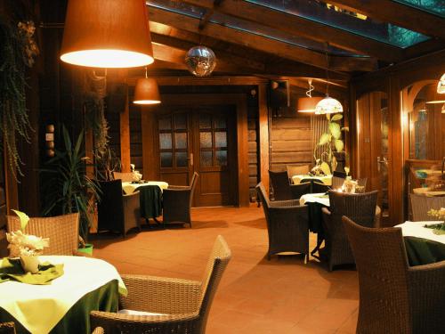 a dining room with tables and chairs and lights at Willa Silesia in Wisła