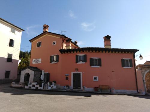 カプリーノ・ヴェロネーゼにあるCasa Del Capitelloの屋根のある大きなオレンジ色の建物