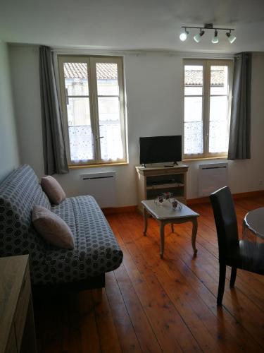 a living room with a couch and a table at beau T2 lumineux 1er etage in Rochefort