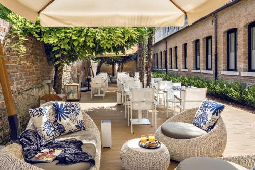 a patio with chairs and tables and an umbrella at Venice Times Hotel in Venice