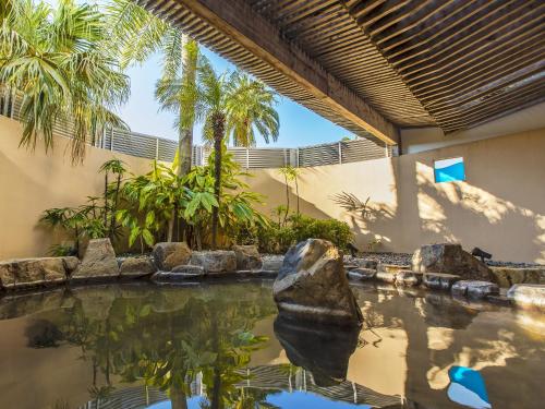 a swimming pool with a rock in the water at Miyazaki Kanko Hotel in Miyazaki