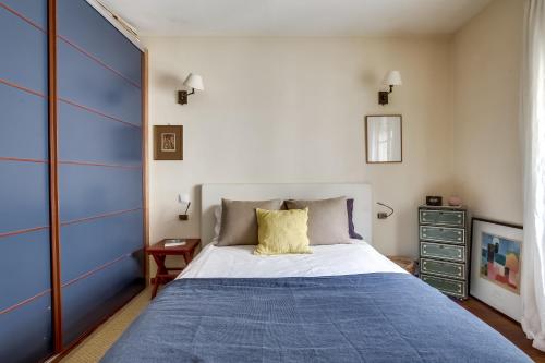 a bedroom with a large bed with a blue blanket at Apartment Tour Eiffel by Weekome in Paris