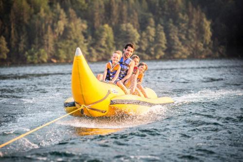 a group of people riding a banana boat in the water at Hotel Trattnig in Döbriach