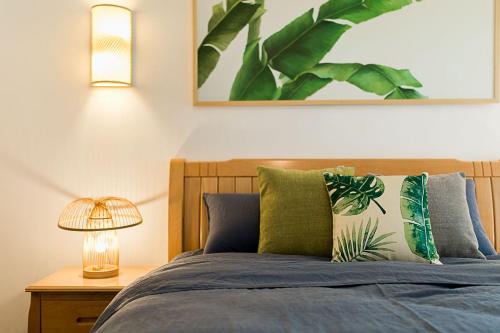 a bedroom with a bed with blue sheets and a lamp at Changsha Changsha County·Mass Media School· Locals Apartment 00148970 in Xingsha