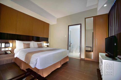 Tempat tidur dalam kamar di The Malibu Suites Balikpapan by Sissae Living