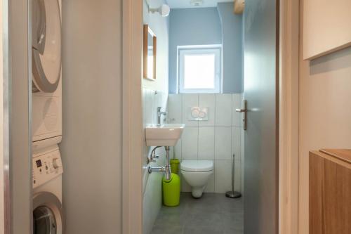 La petite salle de bains est pourvue d'un lavabo et de toilettes. dans l'établissement PERCE NEIGE 1ER, à Morzine