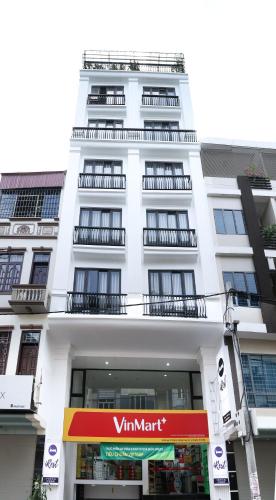 a white building with a vitamin mart sign in front of it at Irest Apartment in Hanoi