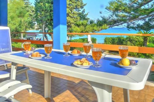 a table with glasses and food on it on a balcony at Villa Doris in Fontane Bianche