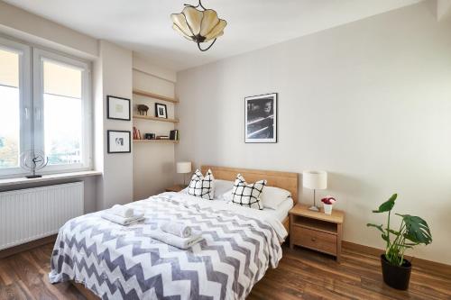 a bedroom with a large bed and a window at Noctis Apartment Tamka in Warsaw