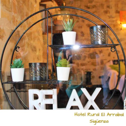 a metal shelf with potted plants on it at Hotel Rural el Arrabal Siguenza in Sigüenza