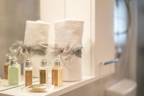 a bathroom counter with four bottles of soap and a mirror at Villa Lucija in Gruda