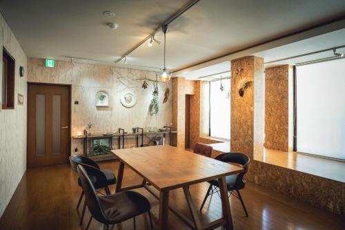 a dining room with a wooden table and chairs at 3LDK Denchi in Matsuyama