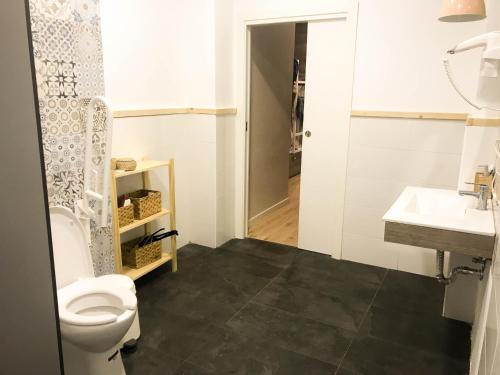 a bathroom with a toilet and a sink at Cantagua Hostel in Valencia