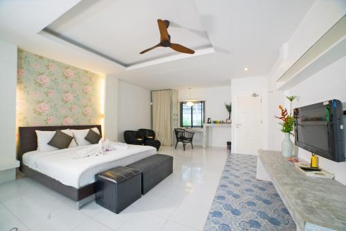 a bedroom with a bed and a flat screen tv at Surintra Boutique Resort in Surin Beach