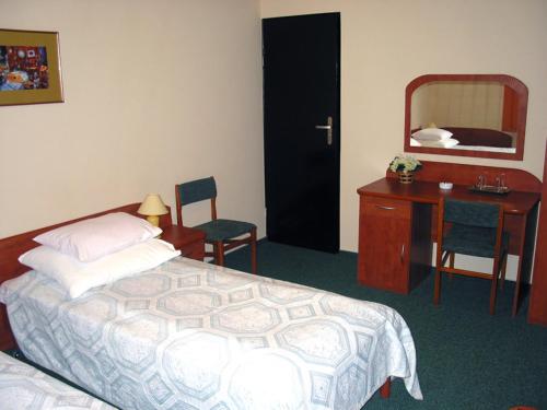 ワルシャワにあるNoclegi Ufoのベッドルーム(ベッド1台、デスク、鏡付)