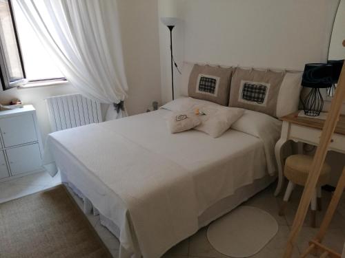 a bedroom with a white bed and a window at Il Vicolo di Ripa B&b in Ripatransone