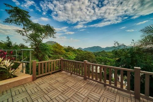 a wooden balcony with a view of the mountains at Sterling Mount Abu in Mount Ābu