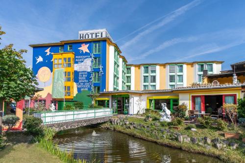 ein Hotel mit einem Fluss vor einem Gebäude in der Unterkunft CONTEL Hotel in Koblenz