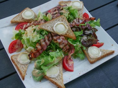 a plate of food with a salad and a sandwich at Hôtel Inn Design Resto Novo Le Mans in Arnage