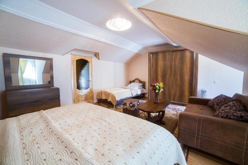 a bedroom with a bed and a couch at Light House Old City in Akhaltsikhe