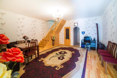a living room with a table and chairs and a staircase at Light House Old City in Akhaltsikhe