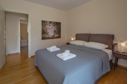a bedroom with a bed with two towels on it at Sagittarius - Faliro Sea Side apartment in Athens