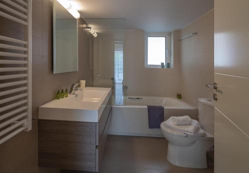 uma casa de banho com um lavatório, uma banheira e um WC. em Sagittarius - Faliro Sea Side apartment em Atenas