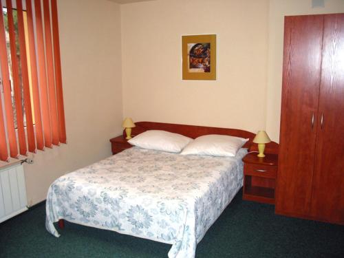 ワルシャワにあるNoclegi Ufoのベッドルーム1室(ベッド1台、ドレッサー、ランプ2つ付)