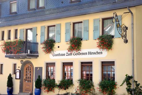 a building with flowers on the front of it at Gasthaus zum Goldenen Hirschen in Martinstein