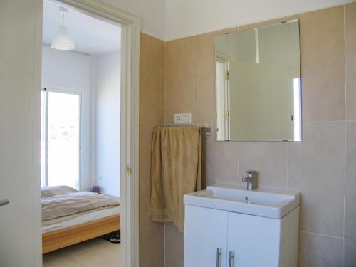 a bathroom with a sink and a mirror and a bed at Casa Bonita in Algarrobo