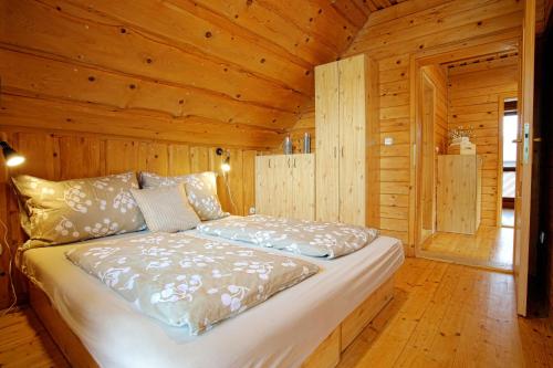 a bedroom with a bed in a wooden cabin at Chaty Mara in Liptovský Mikuláš