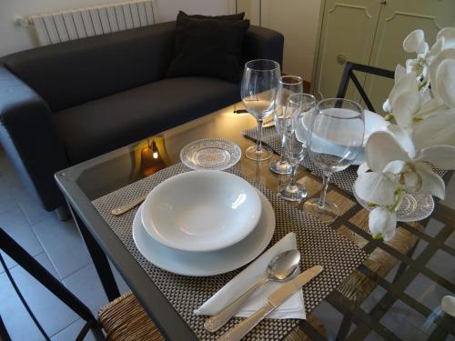 a table with a white plate and glasses on it at CharmeRooms Villa Moroni in Stezzano