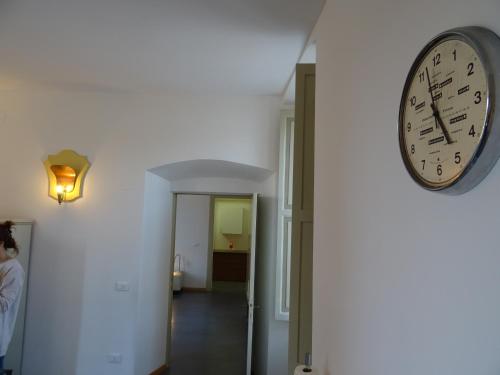 a clock on a wall next to a hallway at CharmeRooms Villa Moroni in Stezzano