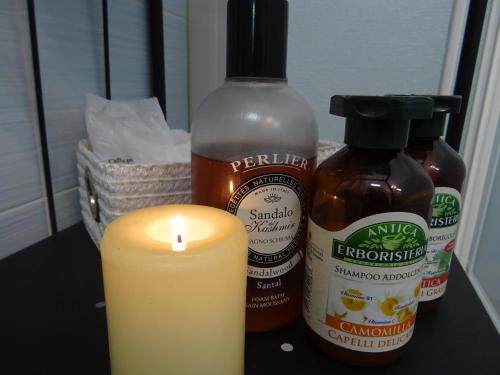 a candle next to a bottle of honey and a bottle of peanut butter at CharmeRooms Villa Moroni in Stezzano
