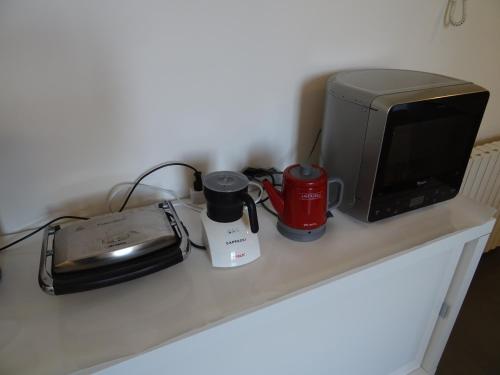 a counter with a microwave and a toaster and a computer at CharmeRooms Villa Moroni in Stezzano