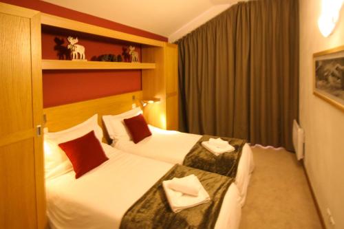 サント・フォア・タロンテーズにあるTime to Ski - Athosのベッド2台と窓が備わるホテルルームです。
