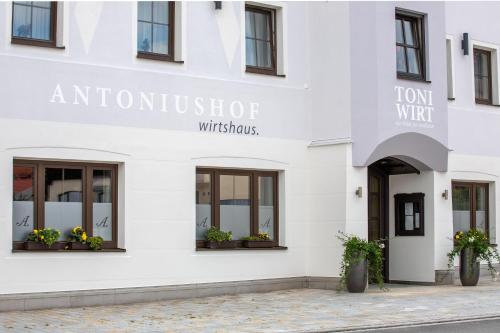 a white building with windows and flowers on the front at Hotel Antoniushof in Ruhstorf