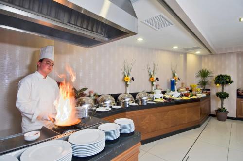 a chef is cooking in a kitchen with fire at Tugcu Hotel Select in Bursa