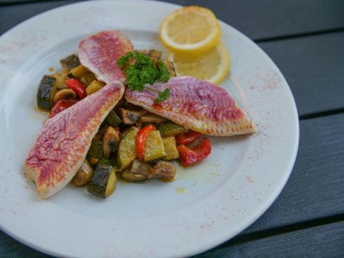 a white plate of food with meat and vegetables at Hôtel Inn Design Resto Novo Bourges in Bourges