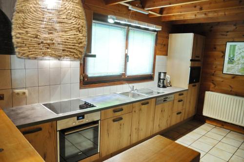 a kitchen with wooden cabinets and a sink at Chalet Le Mirador in Durbuy