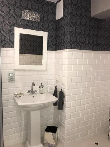 ポズナンにあるMarii Konopnickiej 20の白い洗面台と黒い壁のバスルーム