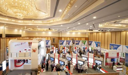 a crowd of people walking around a exhibit in a building at Gulf Executive Residence in Manama