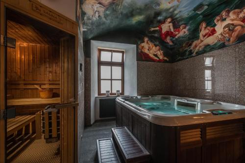 a bathroom with a tub with a painting on the wall at Chateau Krakovany in Krakovany