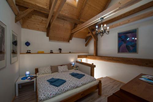 a bedroom with a bed in a room with wooden ceilings at Penzion Krakovice in Kaplice