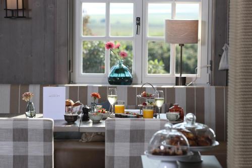 a table with food on it in a room with a window at Landhaus Severin's Morsum Kliff in Morsum
