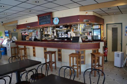 un bar dans un restaurant avec des tables et des chaises dans l'établissement Hotel Pinede, à Saint-Jean-de-Monts