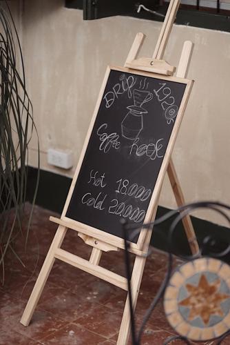 a chalkboard sign on a wooden easel with a sign at Barn1920s Hostel in Vientiane