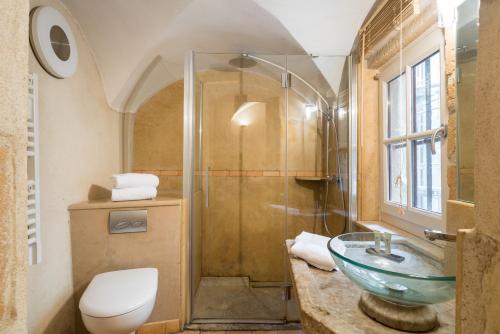 y baño con lavabo de cristal y ducha. en Honorê - Suite Romain Rolland, en Lyon